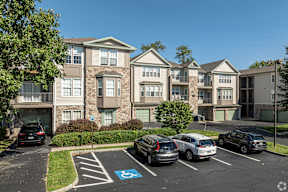 A parking lot with a handicap parking spot in front of apartment buildings.