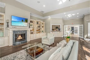 A living room with a fireplace and a flat screen TV mounted above it.