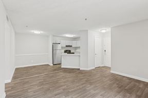 A kitchen with a refrigerator, oven, and cabinets.