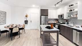 A modern kitchen with a dining table and chairs.