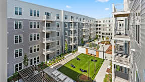 A modern apartment complex with a central courtyard and landscaping.