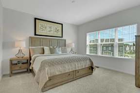 A bedroom with a large bed and a window overlooking a cityscape.