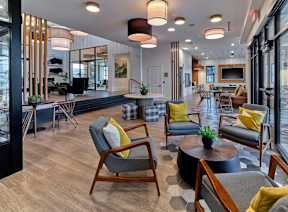 A modern living room with a variety of seating options and a large window.