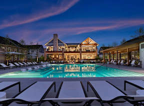 A large house with a pool in front of it.