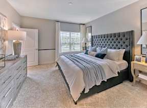 A bedroom with a large bed and a dresser.