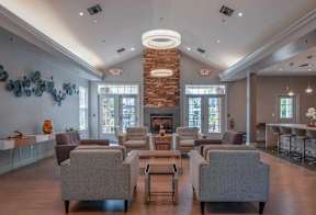Resident lounge at Pennbrook Station Apartments in Lansdale, PA, featuring wood grain flooring and comfortable seating.