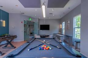 Resident lounge at Pennbrook Station Apartments in Lansdale, PA, featuring a pool table and a television.