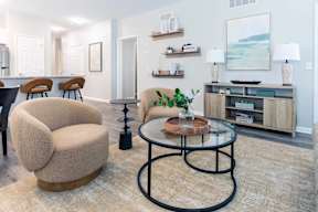 A living room with a glass table and a sofa.