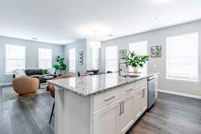 A modern kitchen with a large island and a seating area.