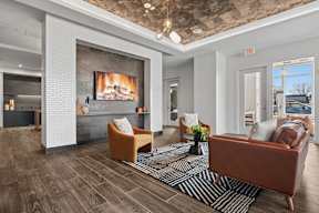 A living room with a fireplace and a brown couch.