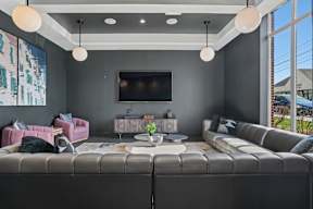 A modern living room with a grey sofa and a television.