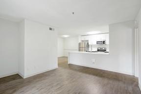 A kitchen area with a microwave, oven, and refrigerator on a countertop.
