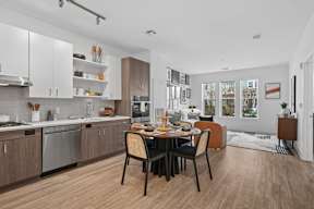 A modern kitchen with a dining table set for four.