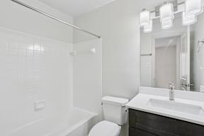 A white bathroom with a toilet, sink, and bathtub.
