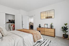 A bedroom with a bed, dresser, and mirror.