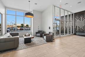 A modern living room with a large window overlooking a parking lot.