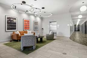 A modern living room with a grey sofa and orange couch.