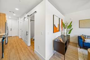 A hallway with a brown cabinet and a painting on the wall.