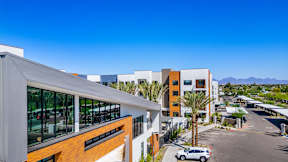 A modern building with a parking lot in front of it.