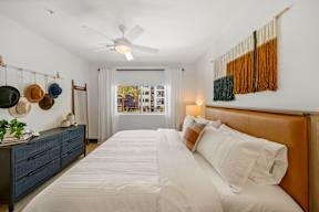 A bedroom with a large bed and a ceiling fan.