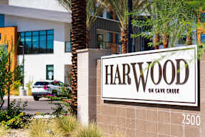 A sign that says Harwood on Cave Creek in front of a building.