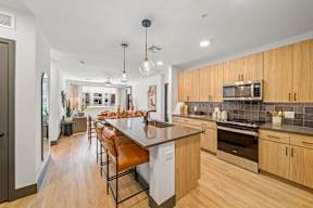 A kitchen with wooden cabinets and a white island.