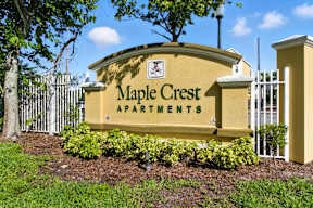 Maple Crest Apartments sign with a tree in the background.