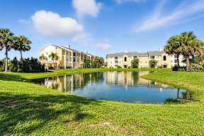 A large building with a pond in front of it.