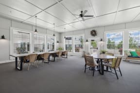 the gathering room with tables and chairs and a ceiling fan at The Hendrickson, Falcon Heights, MN