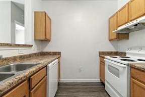 A kitchen with white appliances and wooden cabinets.