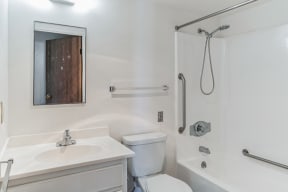 a bathroom with a toilet sink and shower and a mirror