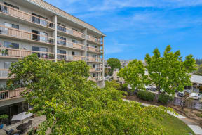 a view of an apartment building with trees in front of it