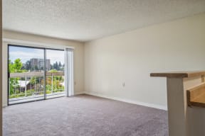 an empty living room with a balcony and sliding glass doors
