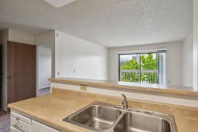an empty kitchen with a sink and a window