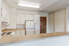 an empty kitchen with white appliances and white cabinets
