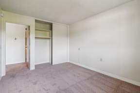an empty living room with a door to a closet