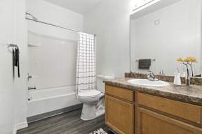 A bathroom with a toilet, sink, and shower.