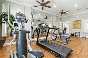 A gym with a treadmill, elliptical machines, and other exercise equipment.