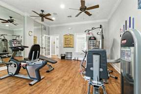 A gym with a treadmill, exercise bike, and other equipment.