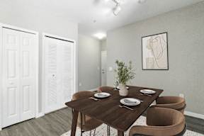 A dining room with a brown table and chairs.