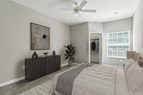 A bedroom with a large bed and a ceiling fan.