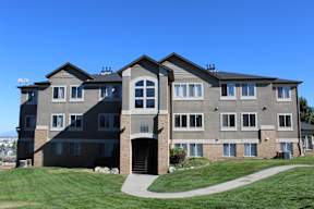 a large apartment building with a sidewalk in front of it