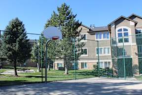 a basketball hoop in front of an apartment building