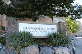 a sign in front of a building that says diamond fork apartments