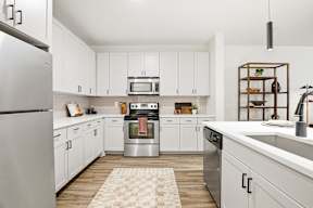 A modern kitchen with white cabinets and stainless steel appliances.