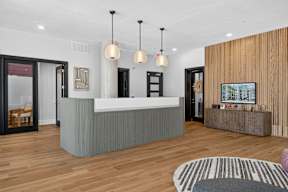 A reception area with a white counter and a wooden wall.