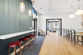 A long hallway with a row of bar stools on the left.