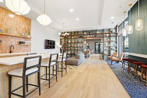 A long wooden table with chairs on either side is in the middle of a room.