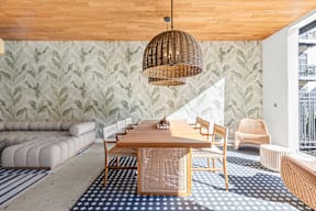 A room with a wooden ceiling and a green leafy wallpaper.