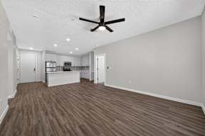 A room with a ceiling fan and wooden flooring.